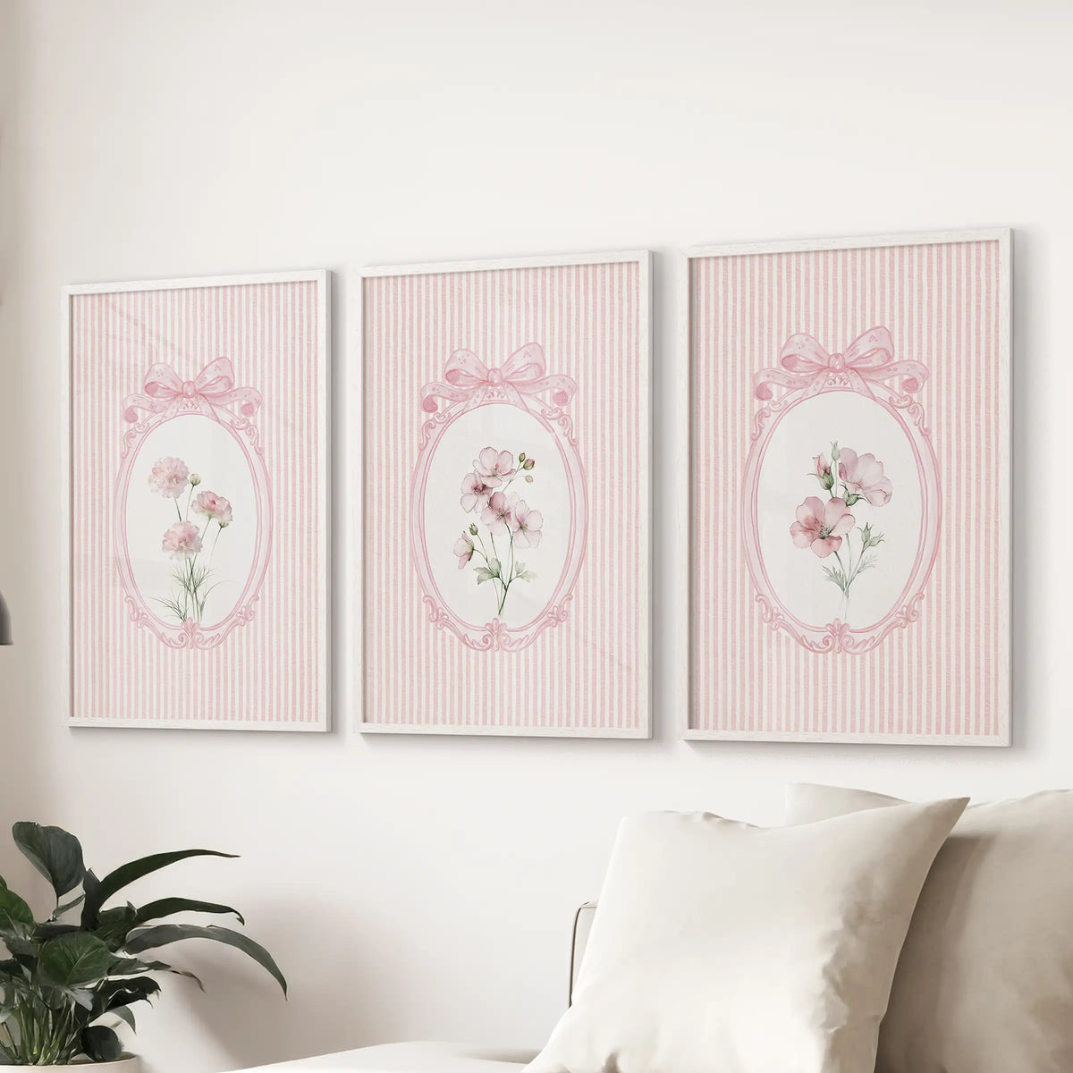 Set of three French pink floral wall prints in white frames over a sectional in the living room.
