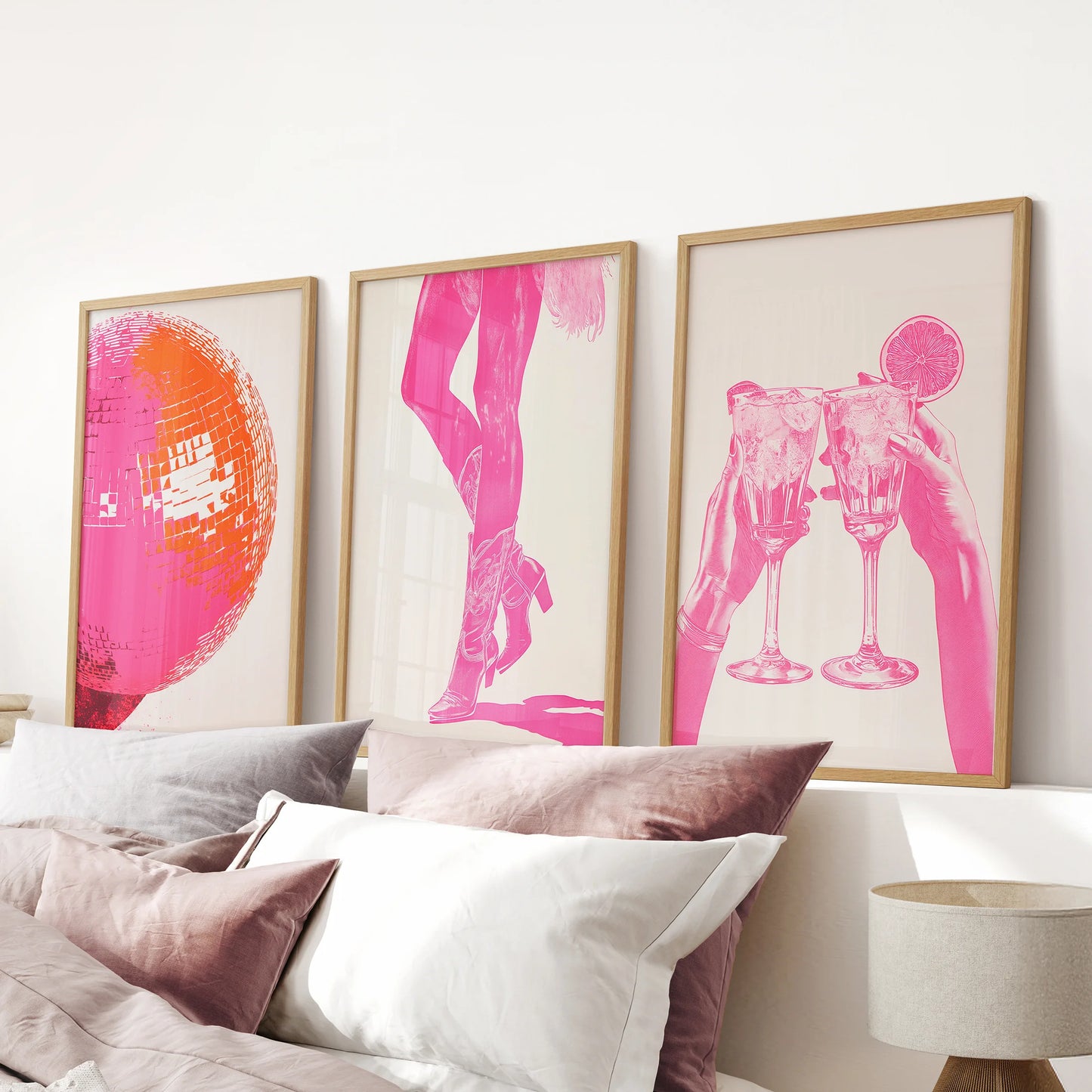 Hot pink abstract prints, a wood-framed set of three above the headboard, energize the pink bedroom with a bold, modern splash.