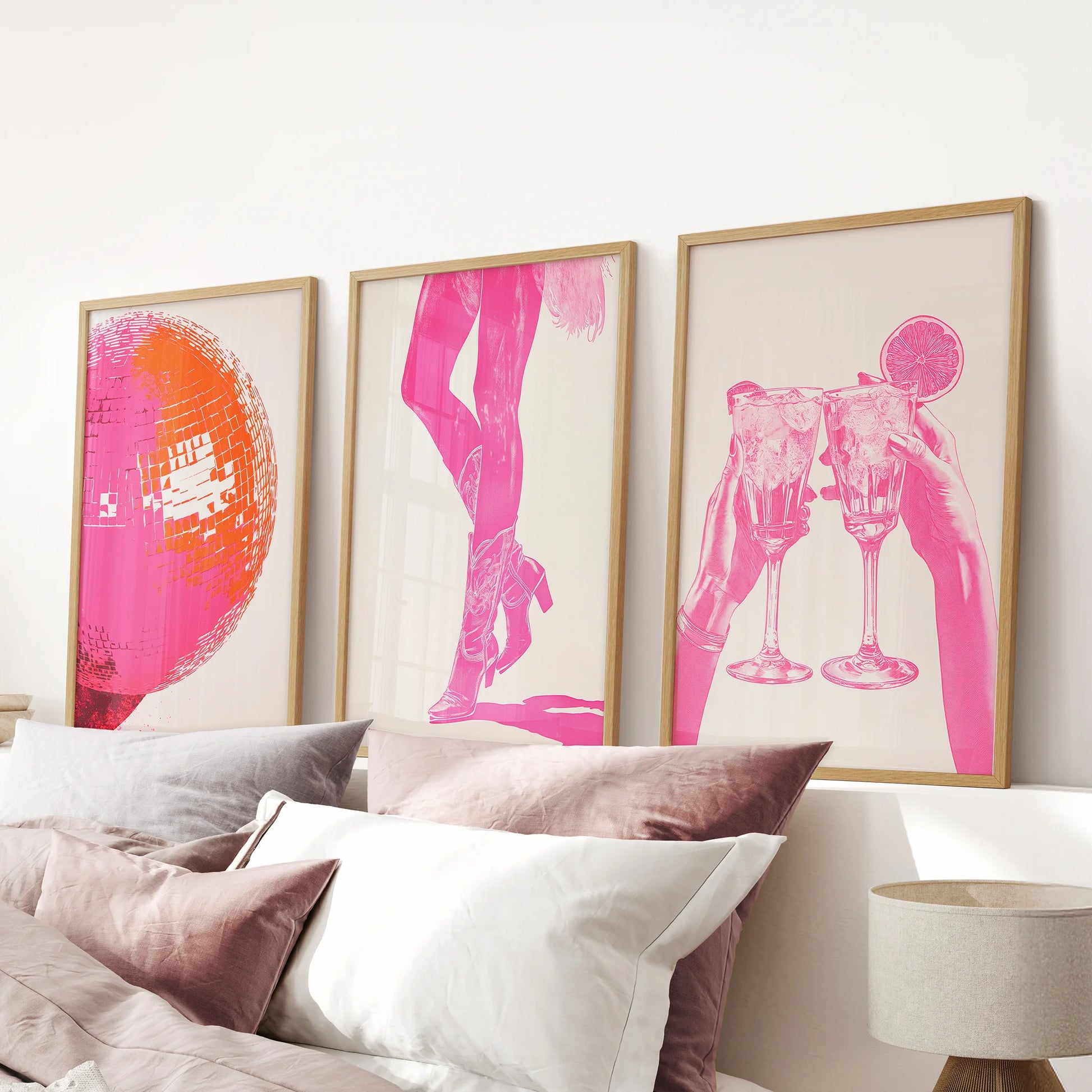 Hot pink abstract prints, a wood-framed set of three above the headboard, energize the pink bedroom with a bold, modern splash.