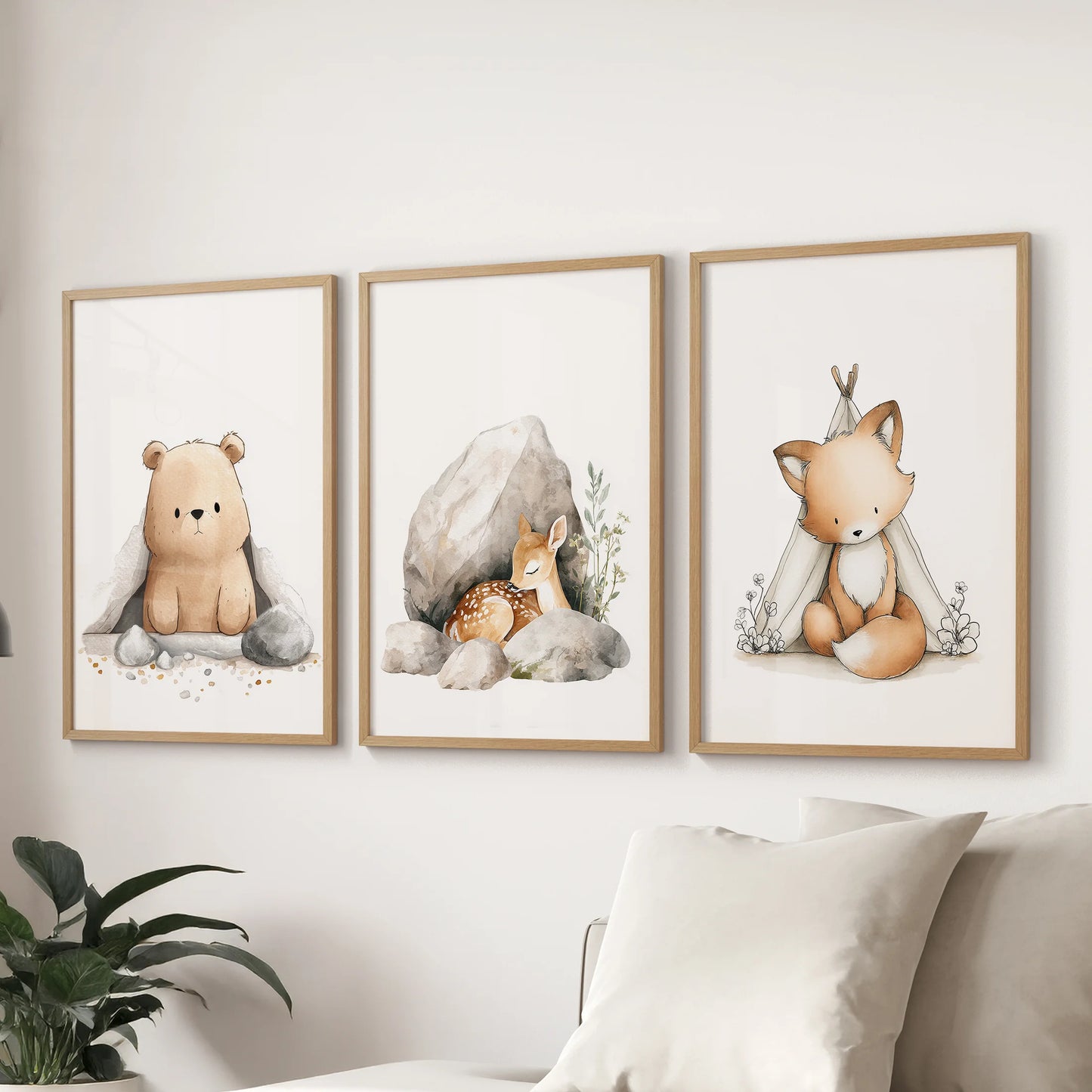 Gallery wall of three light oak framed prints featuring a bear, fox, and deer gathers above the couch with forest calm in the sitting room.