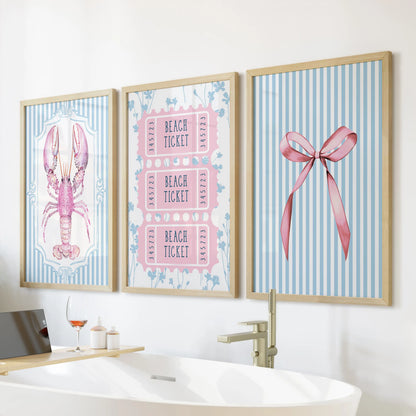 Pastel coastal scenes trio of prints framed in natural oak warms the bathroom wall over a freestanding tub.