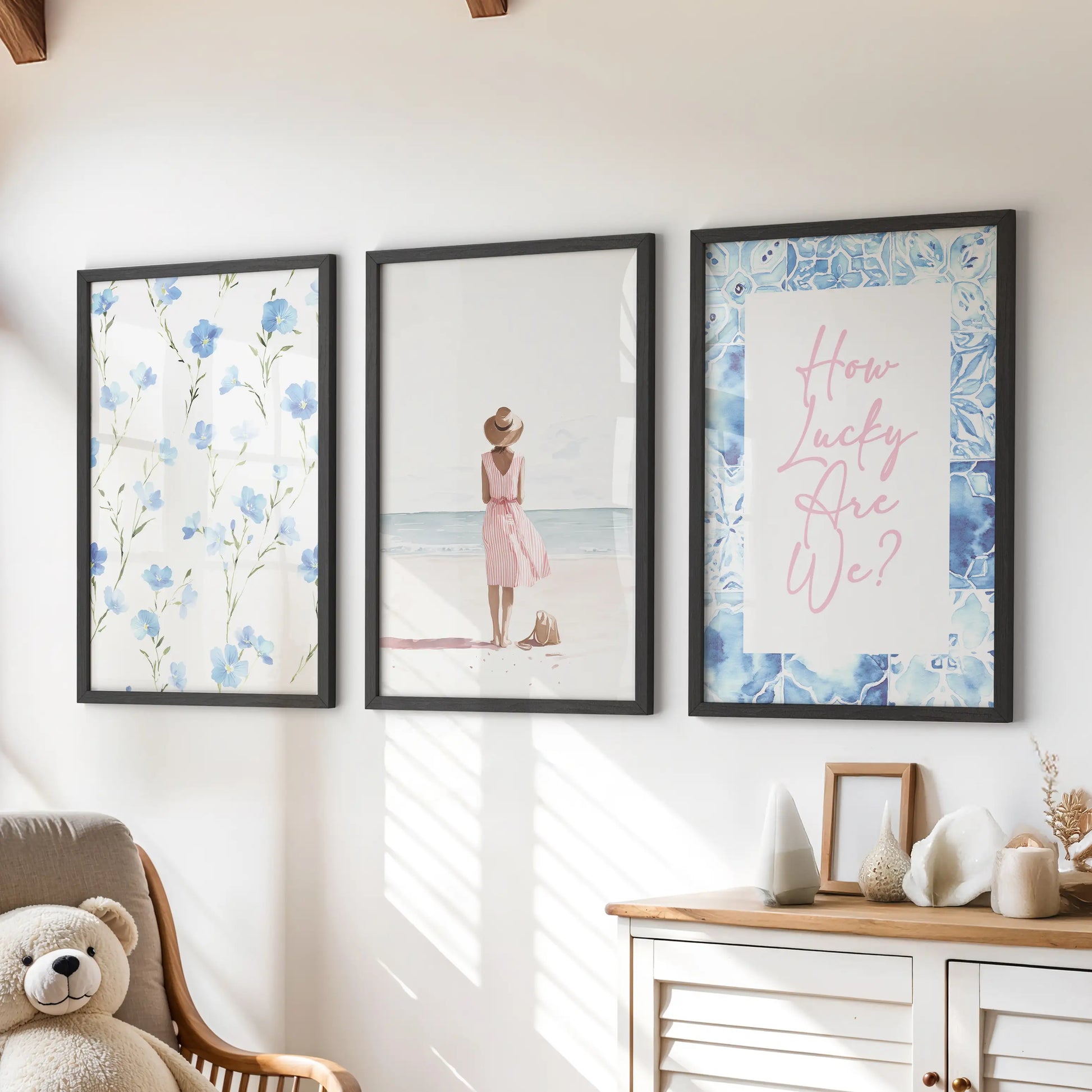 Black-framed wall prints featuring the 'How Lucky Are We' quote form a set of three, arranged above a dresser for a soft, upbeat vibe in the kids playroom.