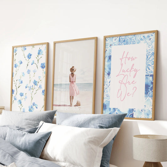 A set of three pastel blue coastal posters in natural oak frames hangs above the bed, infusing the blue bedroom with breezy, shorelight softness.