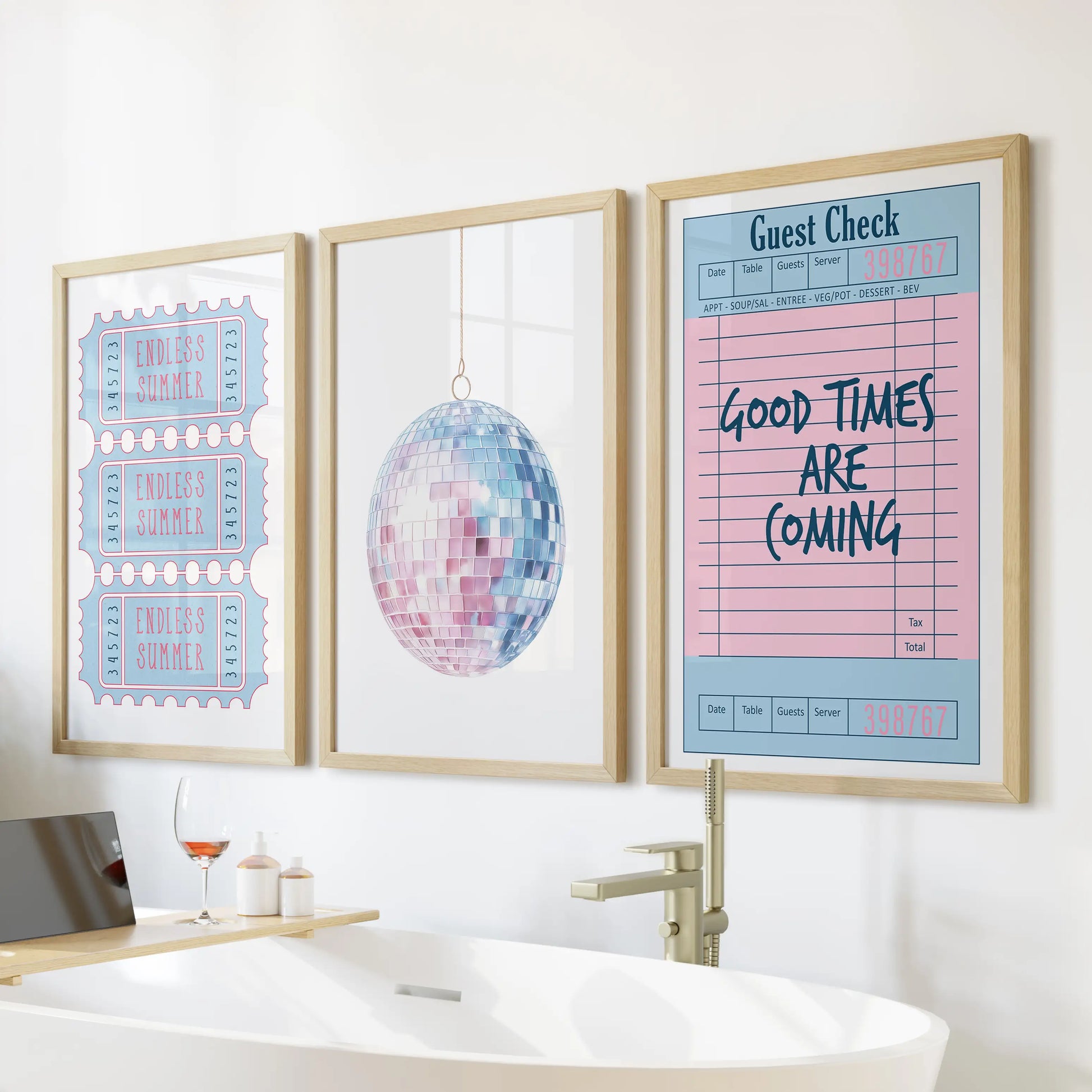 Three art prints in solid oak frames hang above the soaking tub, uniting a beach ticket, disco ball, and guest check for a sunny, feminine refresh.