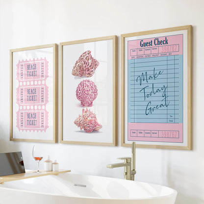 Light-oak frames hold a beach ticket print trio, arranged over a freestanding tub as playful three-piece coastal wall art.