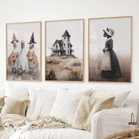 Halloween wall art set of 3 featuring witch ducks, haunted house, and cat lady in vintage dress. Thinwood frames over the couch.