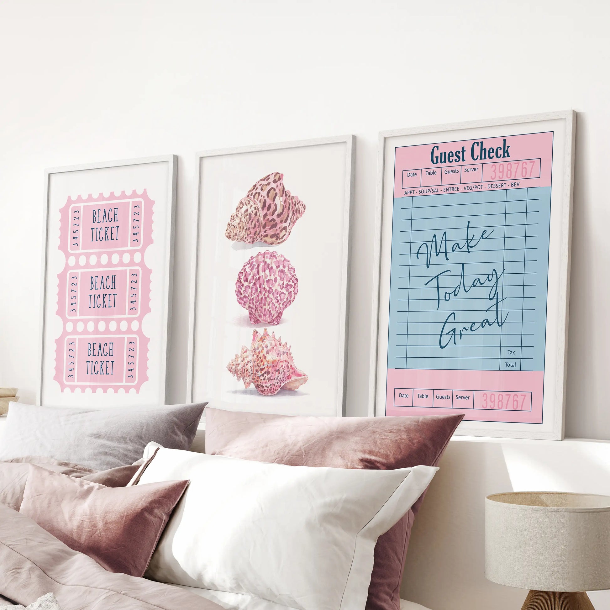 A white-framed gallery trio of guest check prints hangs above the headboard, bringing diner-chic charm to a pink bedroom.