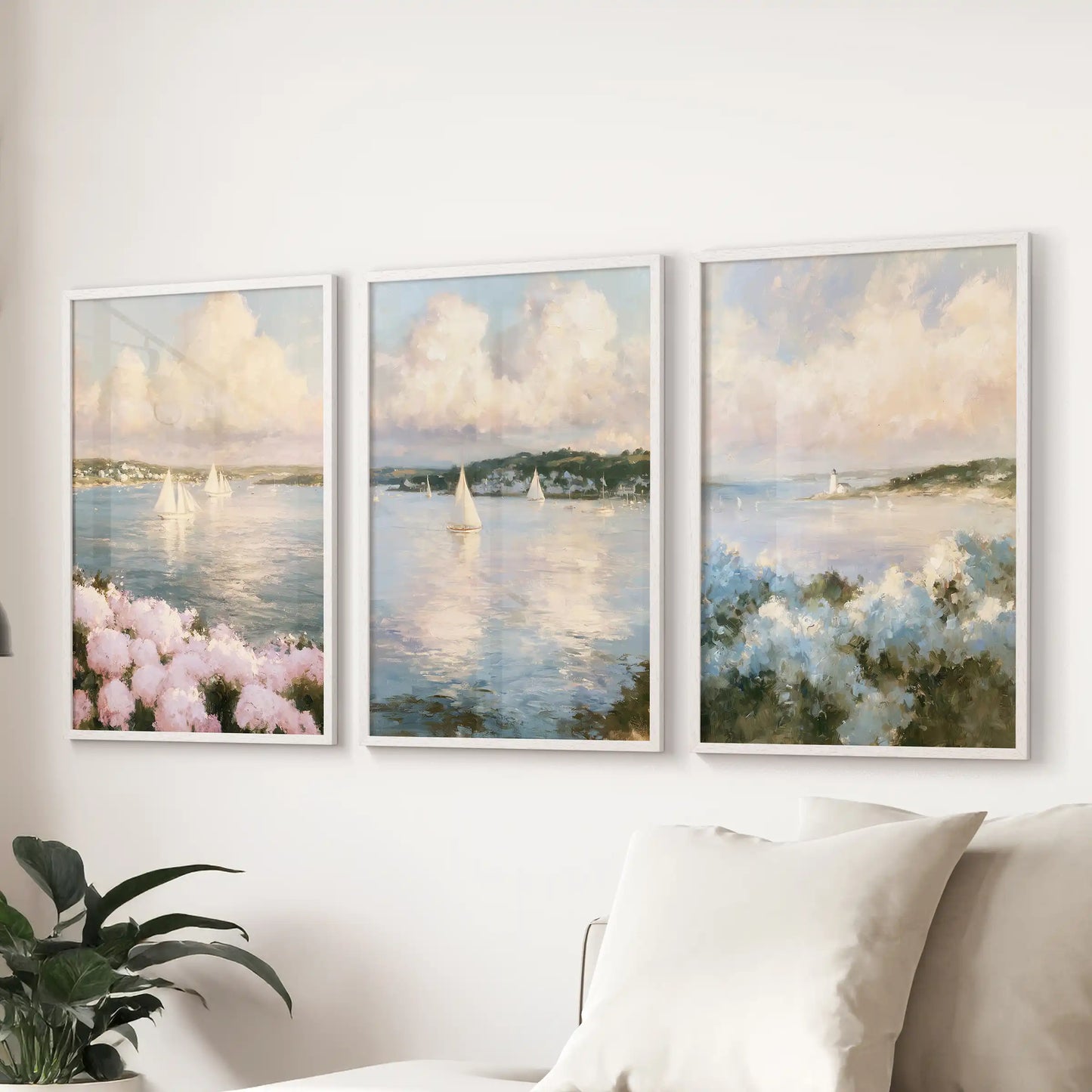 A 3-piece poster set of hydrangea beach flowers hangs behind the lounge sofa. White-framed prints blend blue seas with pink blooms for a gentle coastal feel.
