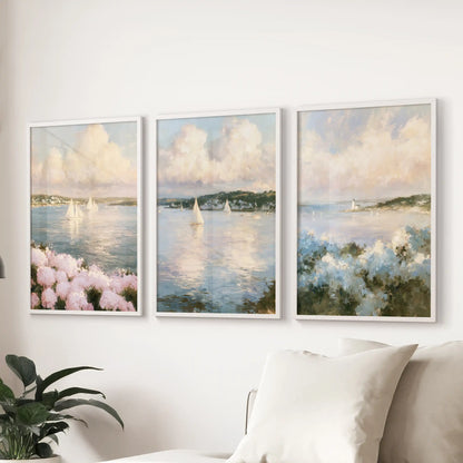 A 3-piece poster set of hydrangea beach flowers hangs behind the lounge sofa. White-framed prints blend blue seas with pink blooms for a gentle coastal feel.
