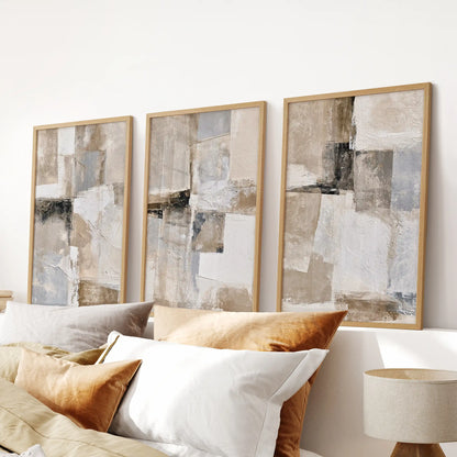 A set of three wall artworks with Scandinavian beige prints sits above the bedroom headboard, with solid oak frames adding natural contrast.