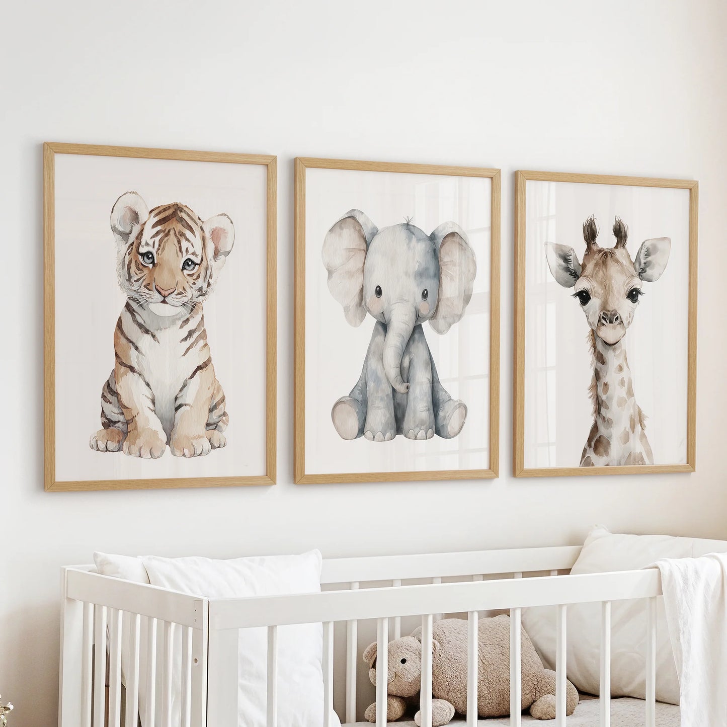 Kids room art: tiger, elephant and giraffe portraits in soft beige and gray tones. Thinwood frames over cot.