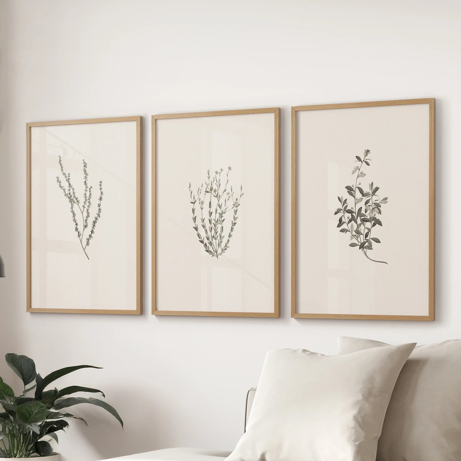 Pressed flowers style three-poster wall art set with thin wood frames finishes the lounge over the couch, offering subtle texture and country ease.