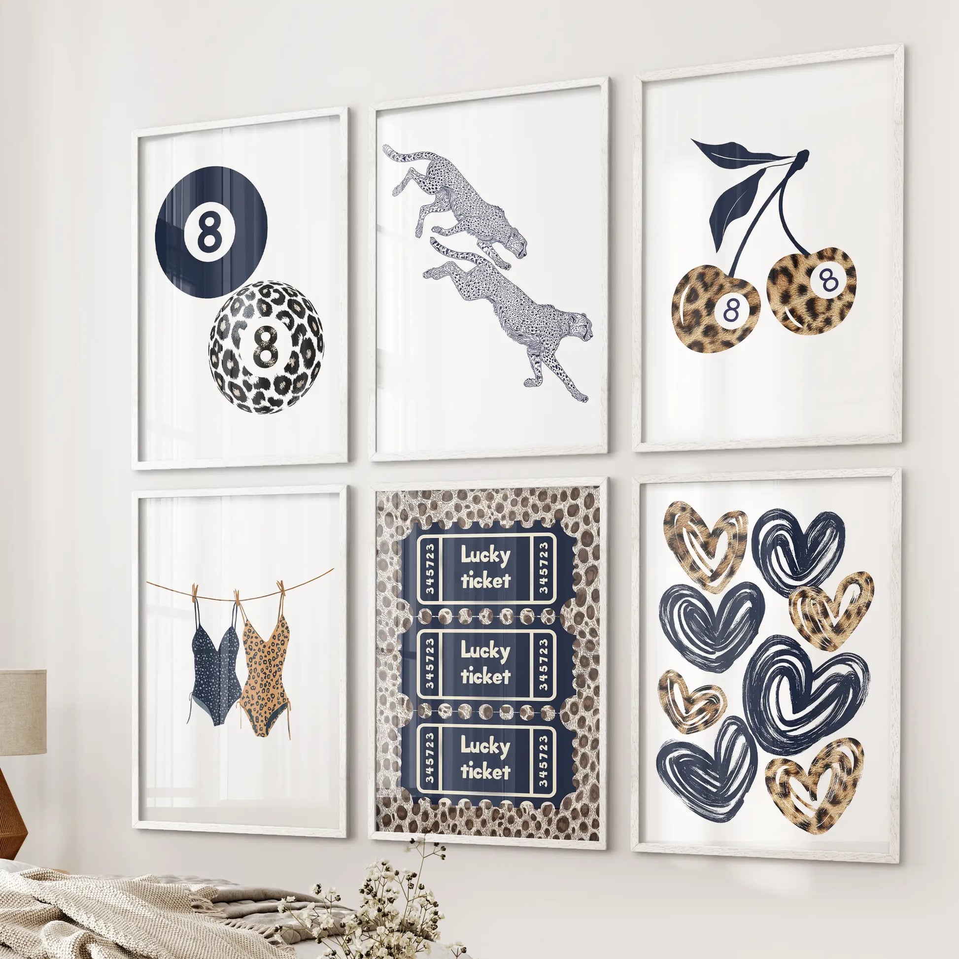 Lucky 8 ball six-piece poster set in white frames adds a playful focal point to a bedroom wall beside the bed, in a navy blue Y2K palette.