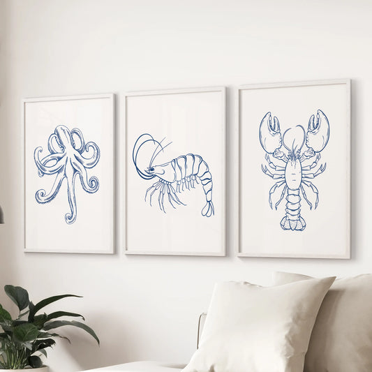 Three-piece marine creatures print set in white frames, forming a clean coastal gallery above the lounge couch.