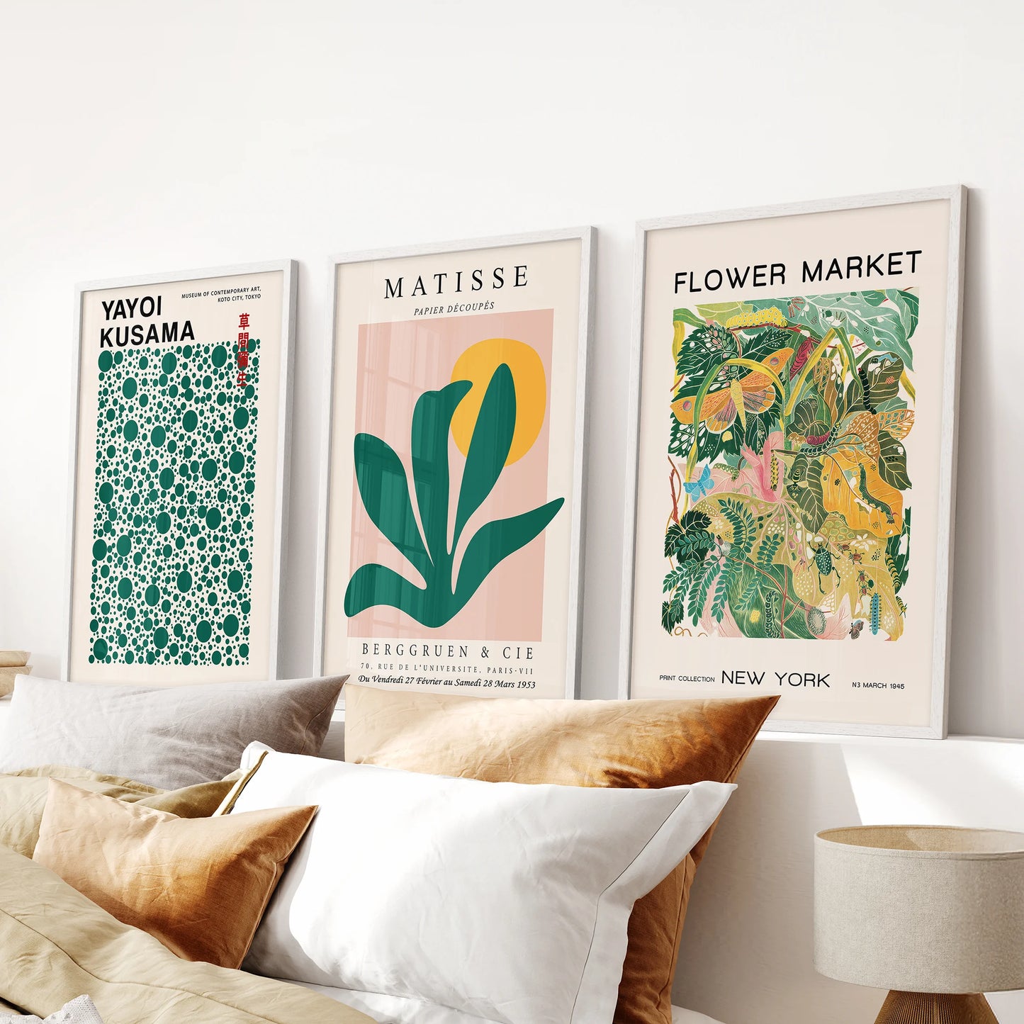 Yayoi Kusama polka-dot art, a set of three wall hangings in clean white frames, placed above the bed headboard to add playful rhythm.