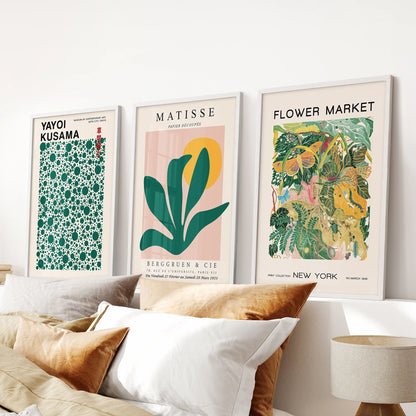 Yayoi Kusama polka-dot art, a set of three wall hangings in clean white frames, placed above the bed headboard to add playful rhythm.