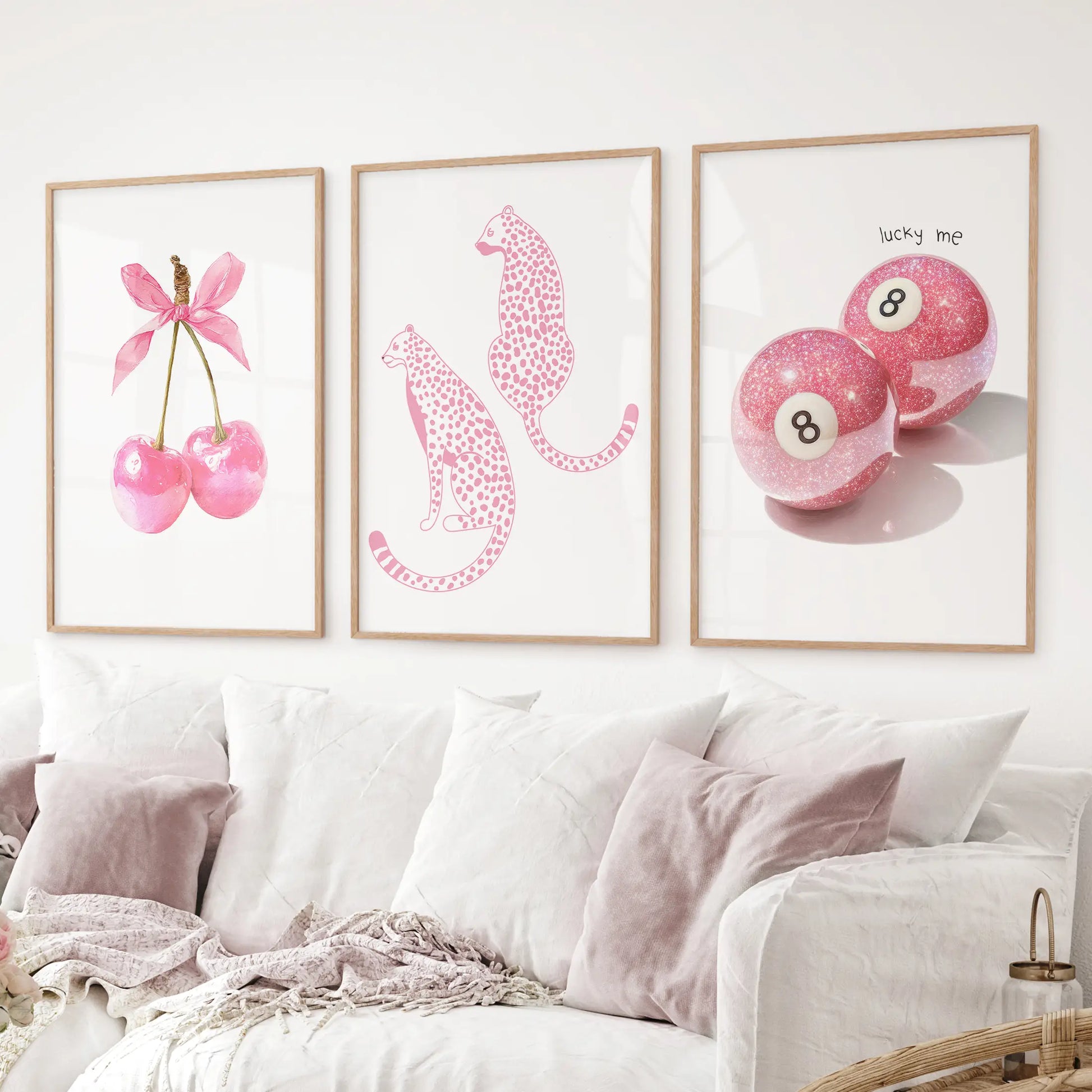 Modern pop-art wall art set of 3 with bold pink designs and playful themes. Thinwood frames over the couch.