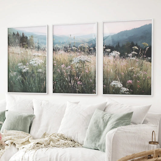 Pastoral nature landscape wall art set. Floral fields and misty mountains art posters. White frames over the couch.