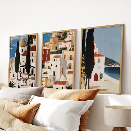 A 3-print wall set of sea horizon views in light wood frames hangs over the headboard, calming the bedroom with airy blue tones.