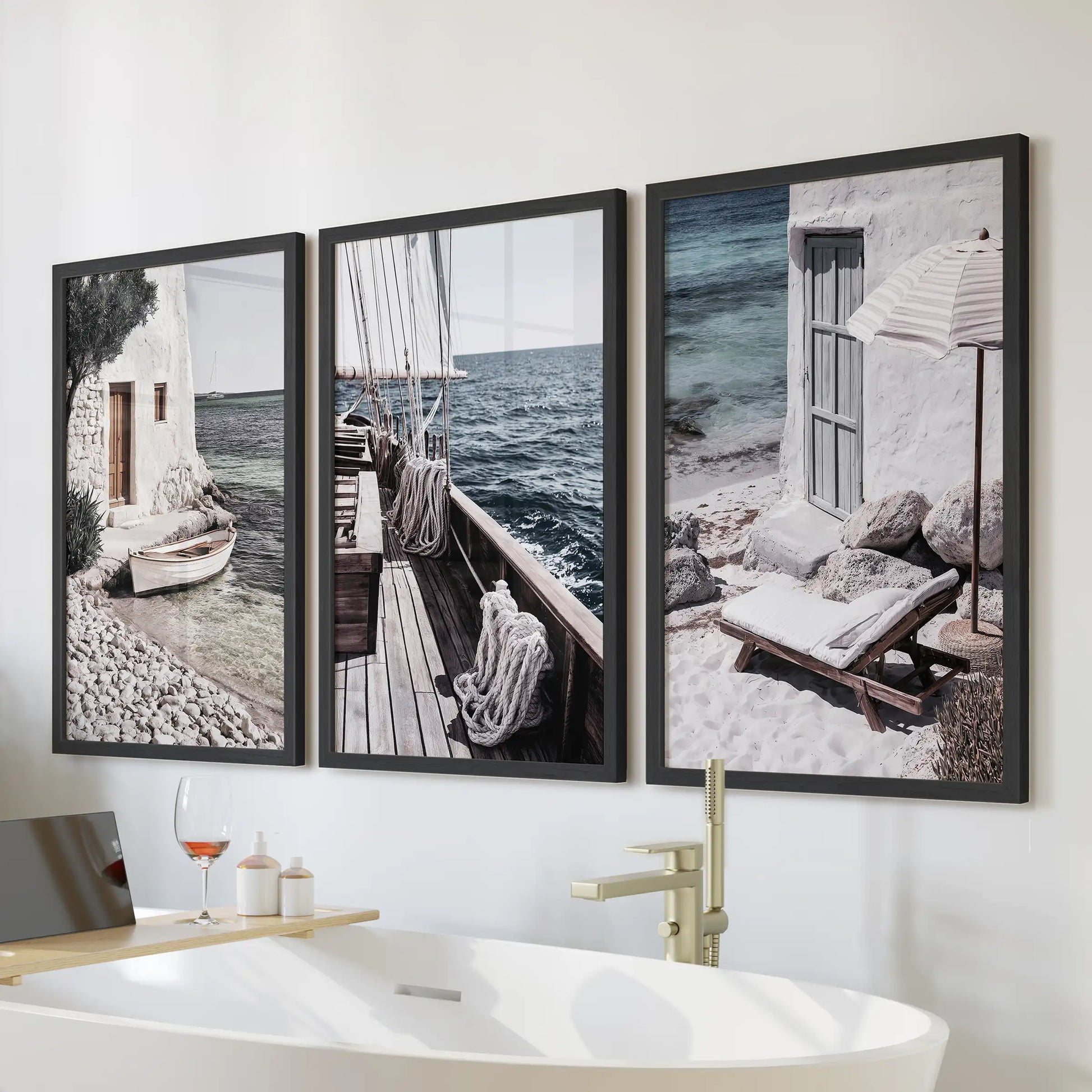 Mediterranean sailboats wall art, a set of three in black frames, placed above the bathtub to bring a breezy coastal lift to a calm bathroom.
