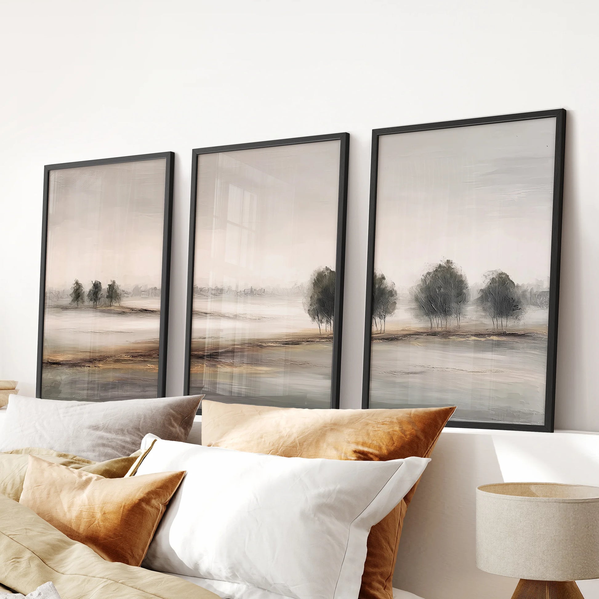 Minimalist beige landscape triptych, a 3-piece wall art set in black frames, hangs over the bed headboard to anchor a serene bedroom with soft, neutral tones.