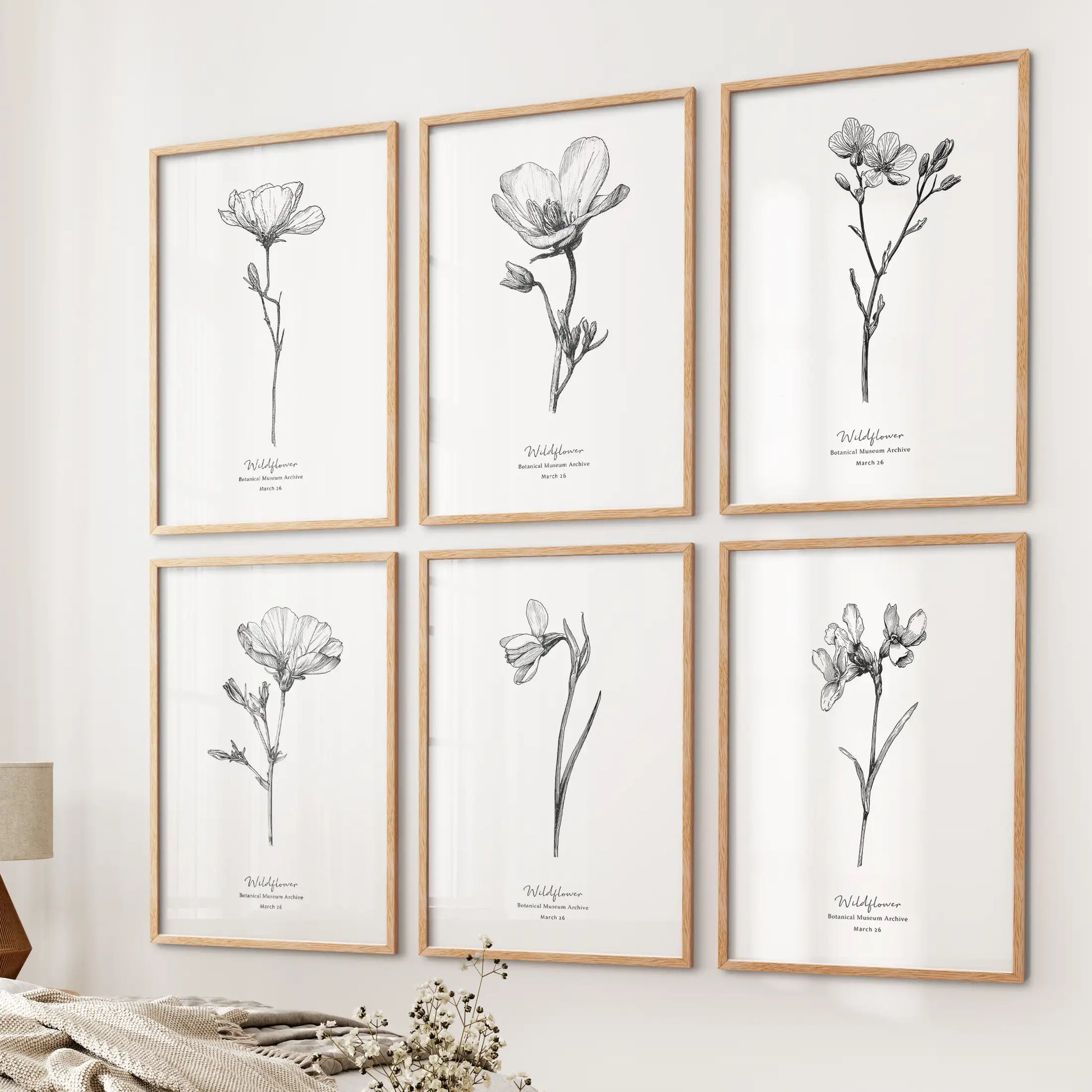 Dried floral sketches, a gallery of six wall prints, warm the bedside wall in wood frames, blending minimalist line art with a softly rustic farmhouse mood.