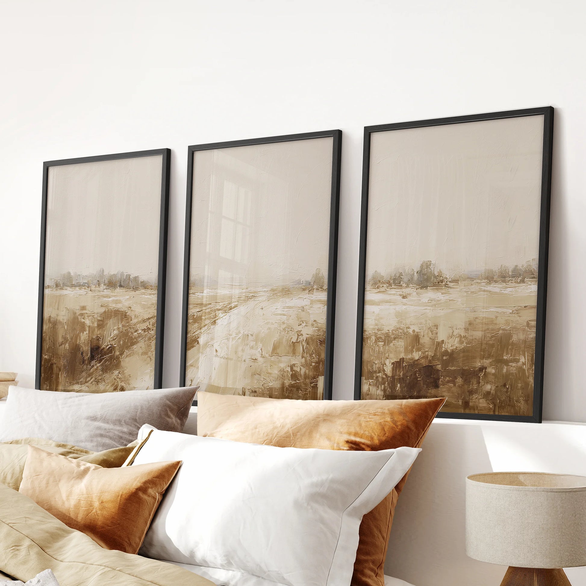 Three-piece wall art with neutral abstract landscapes in black frames adds a calm touch to a bedroom when displayed above the headboard.