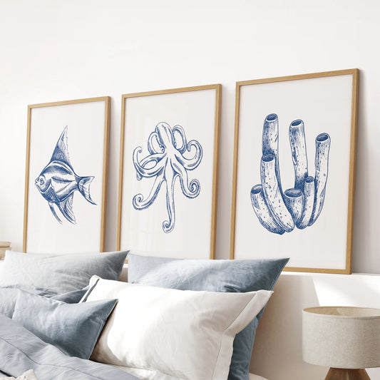 Blue fish prints three-print bundle with warm wood frames, tailored for a blue bedroom and set above the bed's headboard for clean coastal lines.