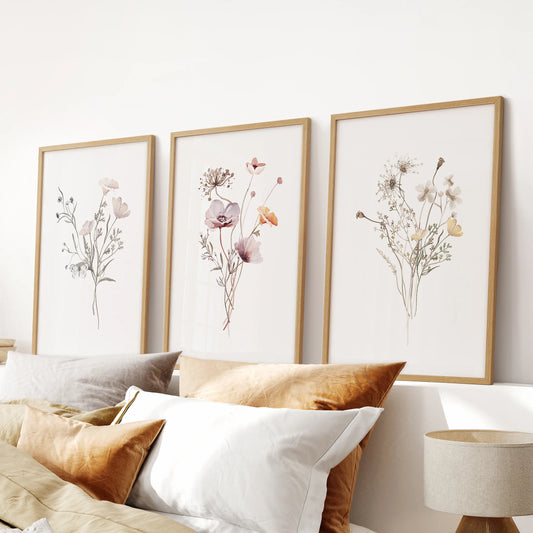 Natural wood-framed prints wildflower botanicals, a 3-panel wall art series, sit above the headboard to ground a restful bedroom.