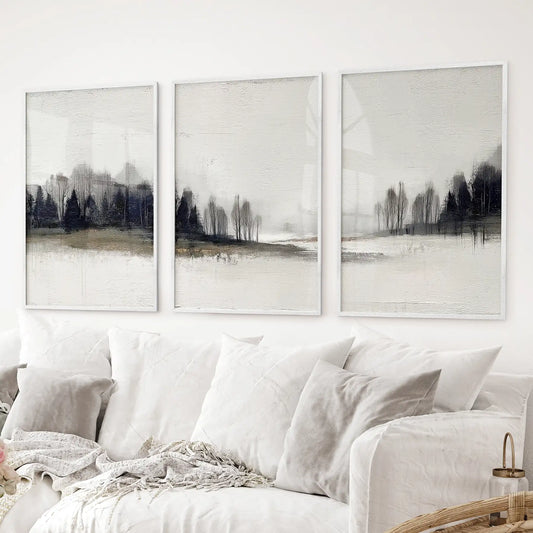 Set of 3 forest prints featuring misty trees and earthy horizon. White frames above the sofa.