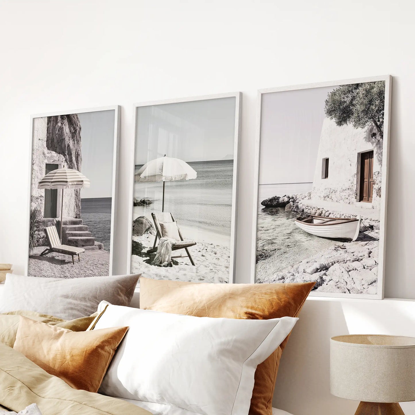 Neutral-toned coastal landscapes, three framed prints in white forming a clean gallery above the headboard, bringing hush and light to the bedroom.