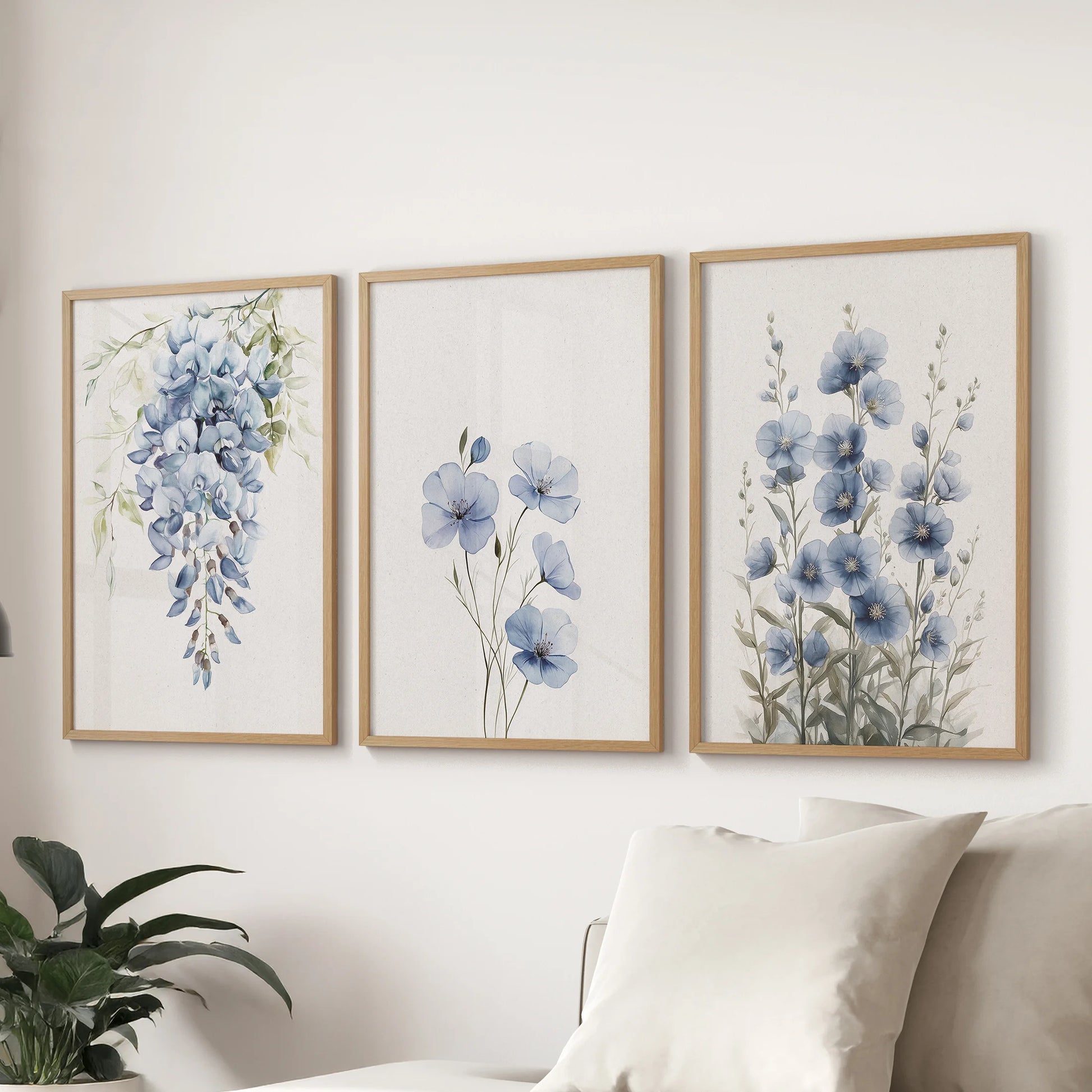 Modern floral prints form a 3-piece gallery wall in light oak frames above the sectional in the sitting room, delivering airy blue botanicals at scale.