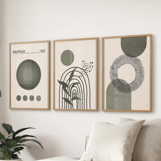 Mid-century modern abstract shapes, three prints in slim wood frames, create a clean focal wall in the living room over the couch.