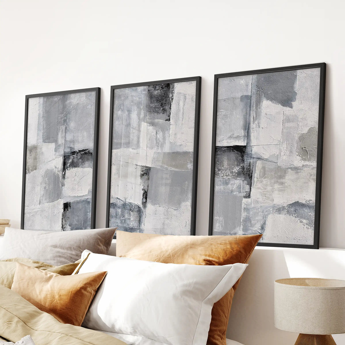 A trio of Japandi neutral-form posters brings a serene focal point above the bedroom bed, presented in slim black frames.