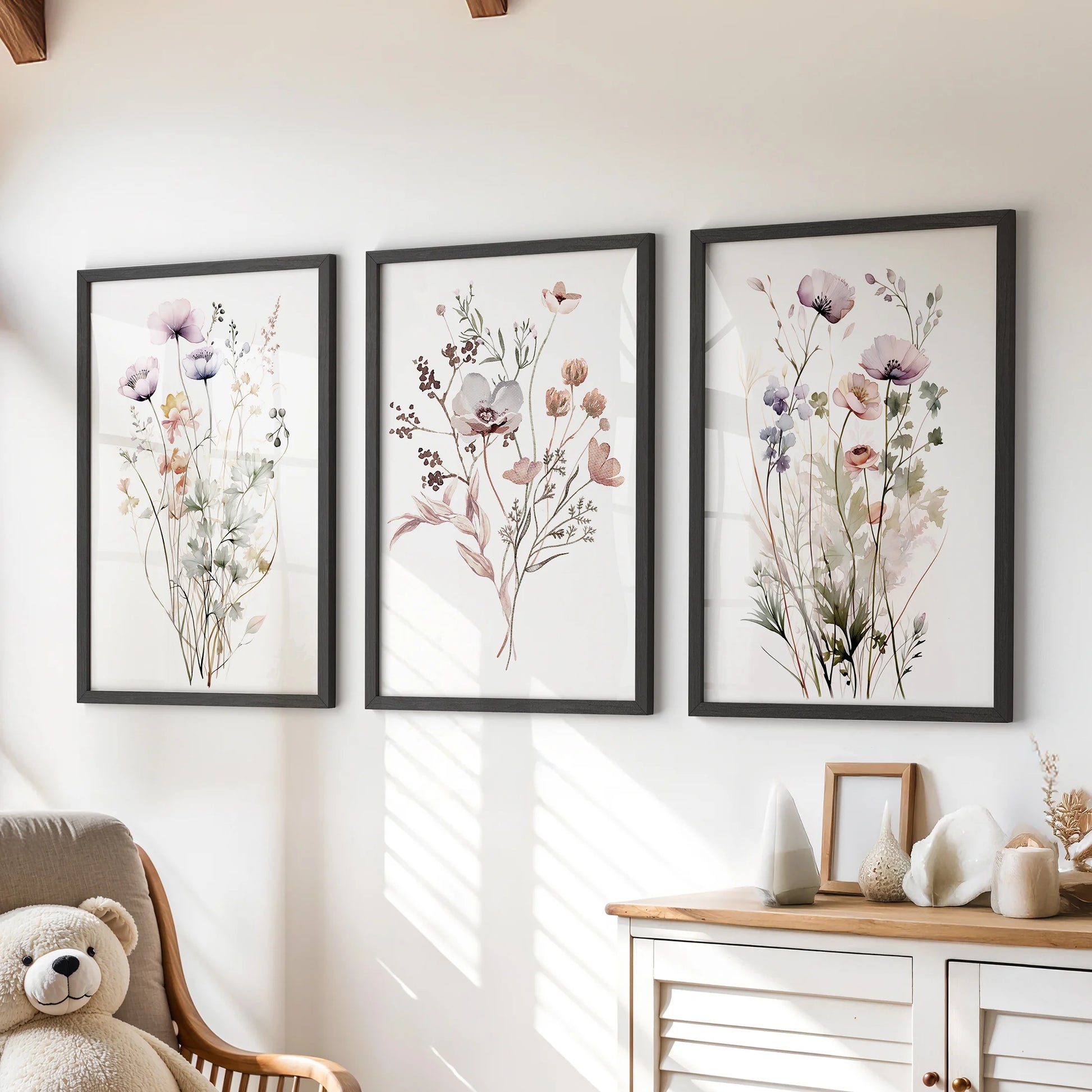 Watercolor wildflowers wall art, a 3-piece set, in black frames over a chest of drawers to brighten a children's room.