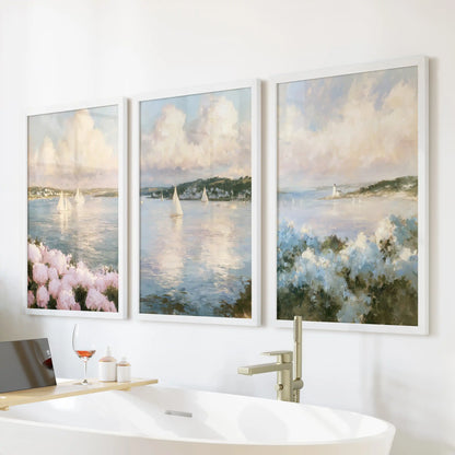 A 3-piece wall art set of an ocean and sky seascape hangs above the bathroom tub. White frames keep the coastal look light and airy.