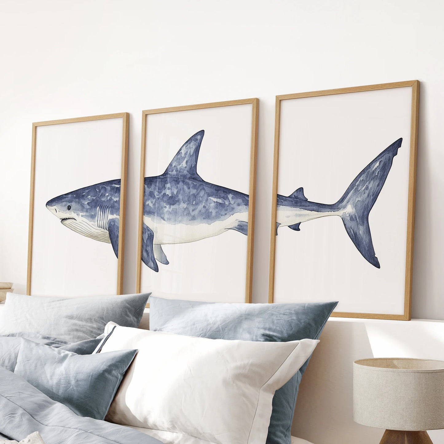 Three-piece watercolor marine prints art in wood frames brings nautical charm to a pink bedroom, sailing gracefully above the headboard.