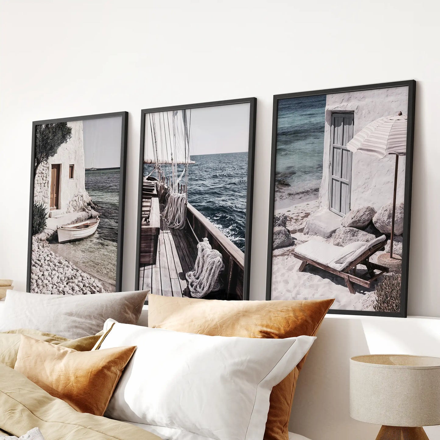 This three-piece poster set features luxury yachts in slim black frames, styled above the bed as a refined coastal focal point for the bedroom.