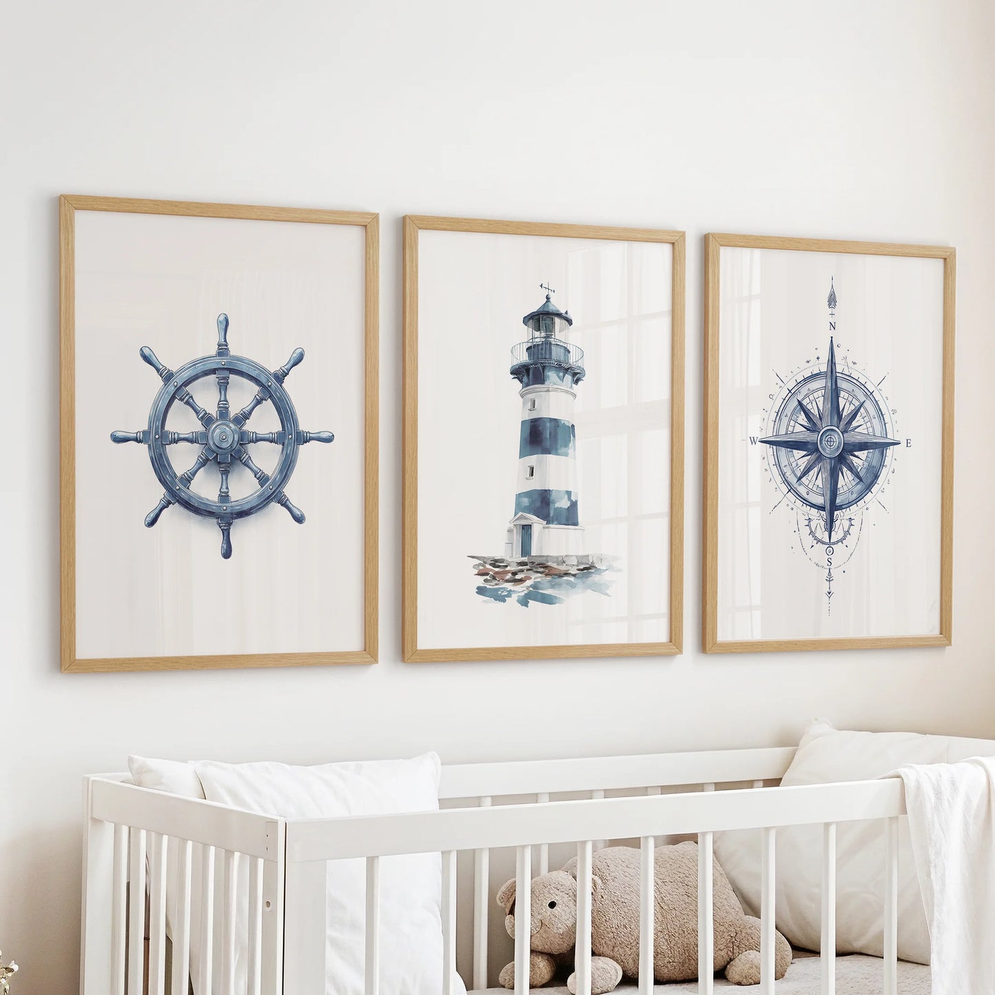 Three nautical wall art prints in natural wood frames cast a gentle navy glow in the nursery, hanging over the bassinet.