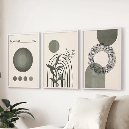 A white-framed set of three geometric wall art pieces brings soft sage and neutral tones to the lounge wall above the sofa.