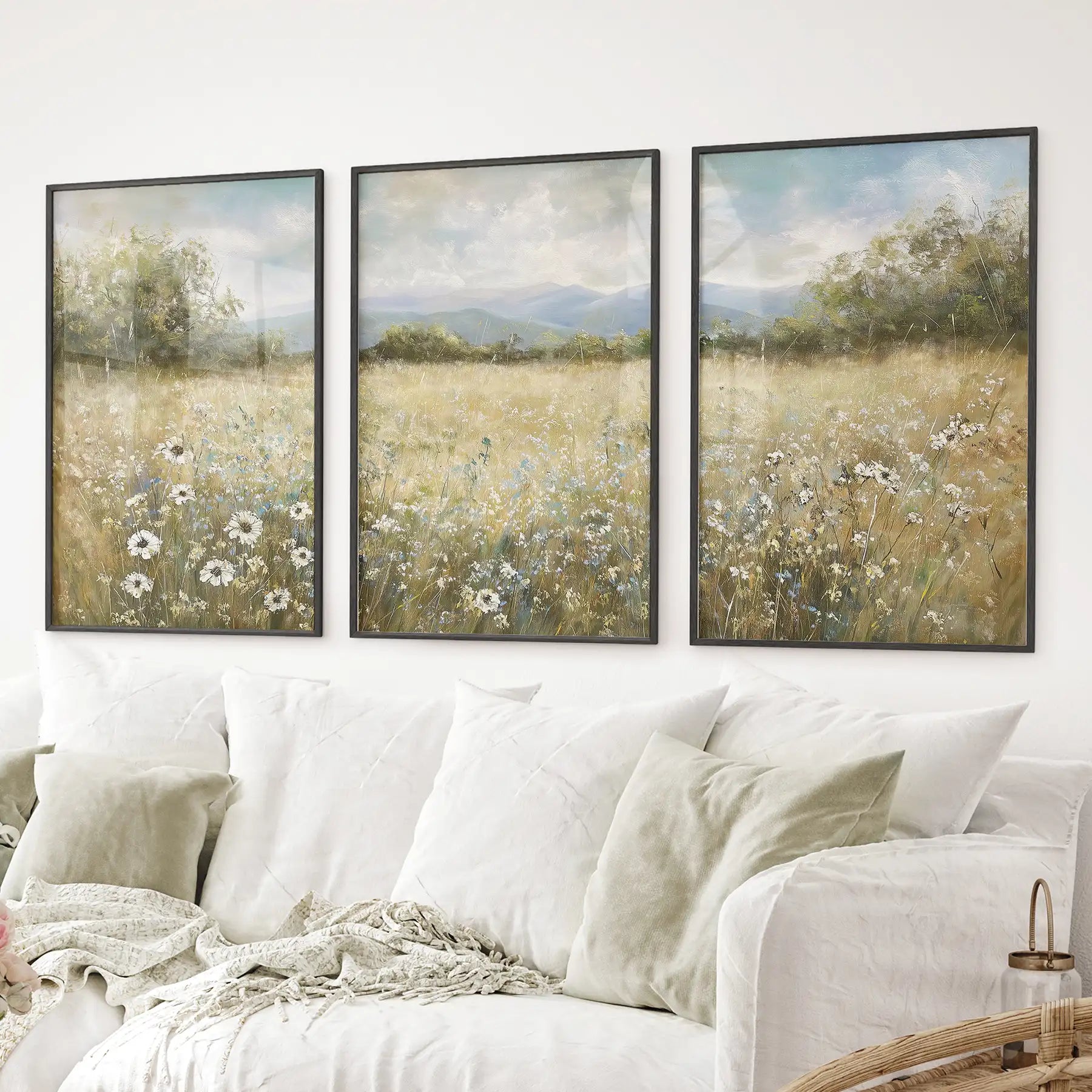 Farmhouse style wall art featuring meadow scene with soft colors. Black frames above the sofa.