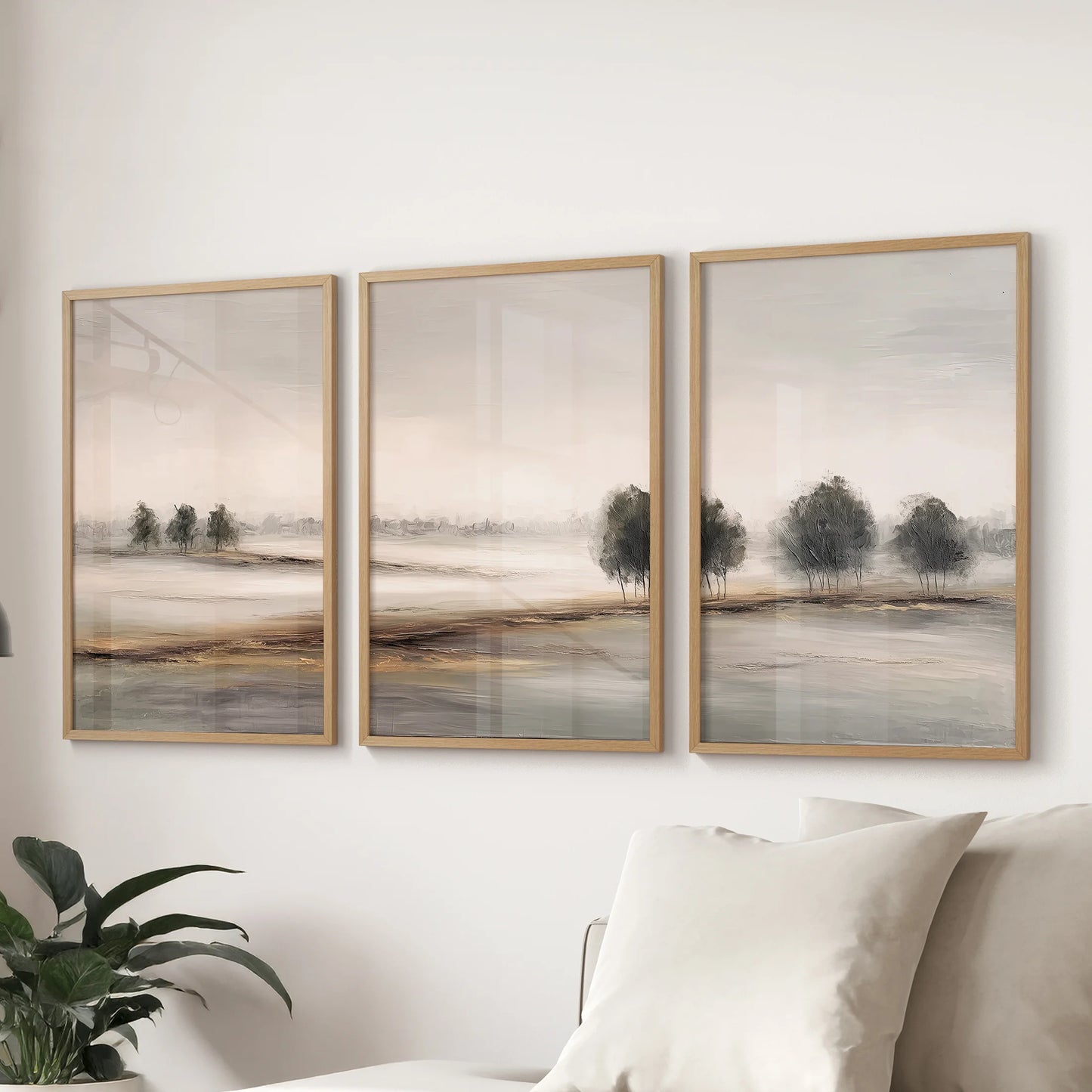 Neutral landscape poster trio, a three-poster bundle in oak frames, lines up behind the couch to give the sitting room a soft, minimalist horizon.
