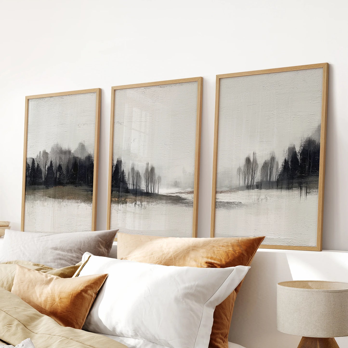 Modern wilderness landscape, a gallery set of three wall prints in warm oak frames, finishes the bedroom scene over the headboard.