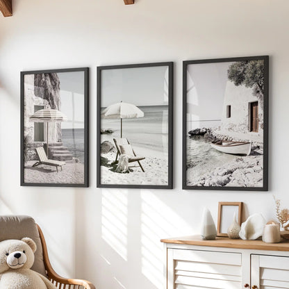 Framed wall art features three neutral-toned coastal landscapes in black frames. Arranged above the dresser, the set softly grounds a children's room with a quiet seaside mood.
