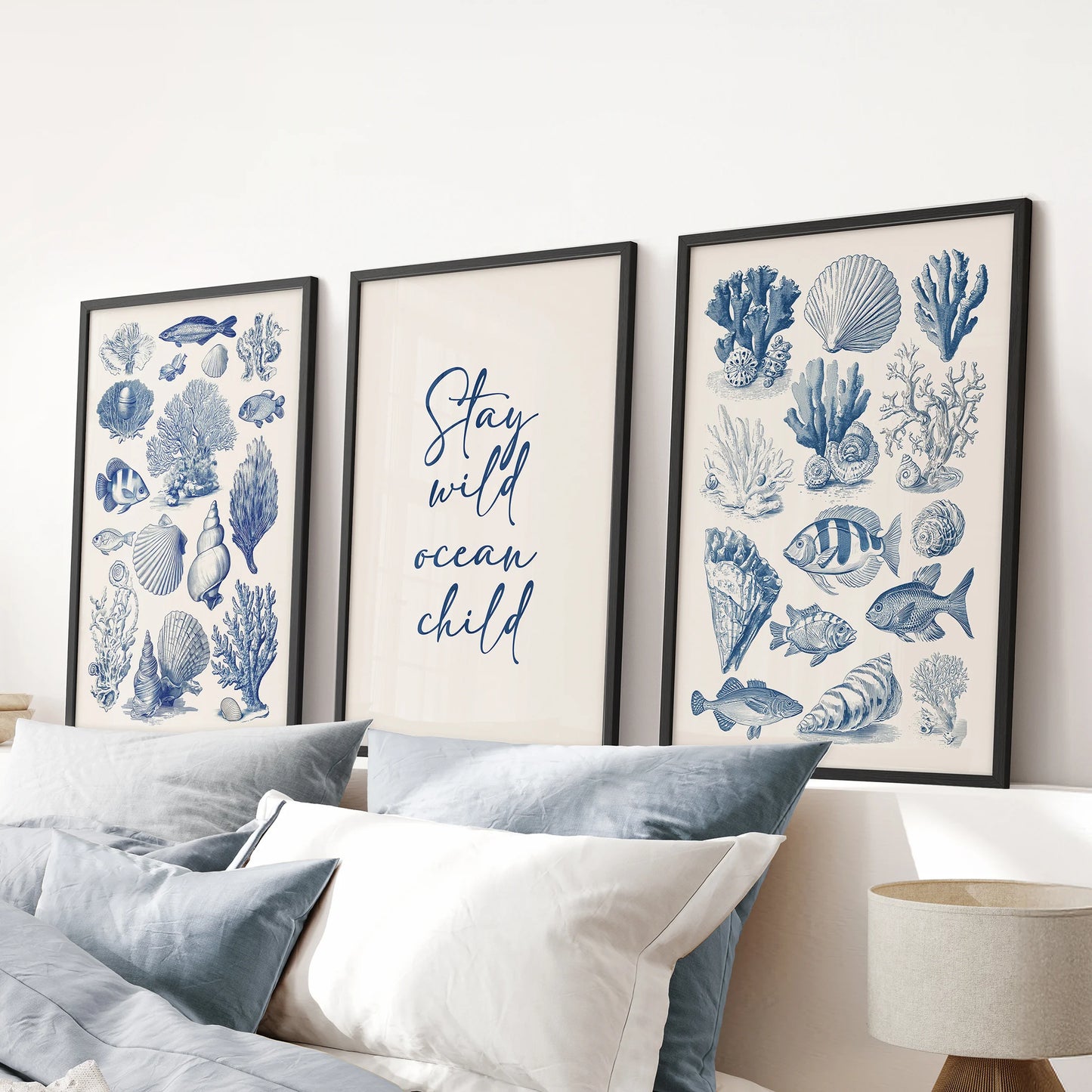 Large ocean typography poster wall art set of three in black frames adds subtle depth and movement above the blue bedroom headboard.