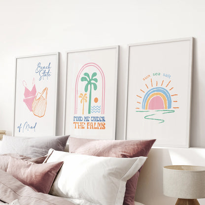 Sun and sea prints, white-framed, 3-piece wall art, brightens the pink bedroom above the bed with soft blue and blush tones.