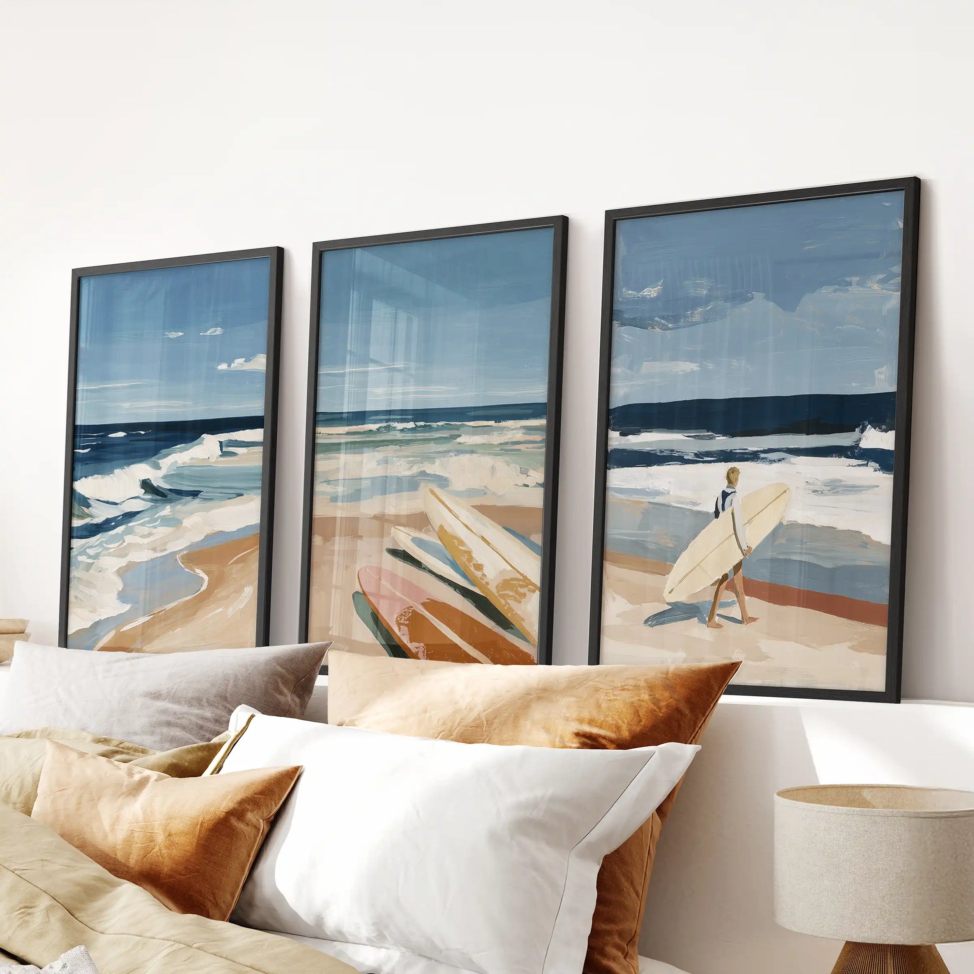Surfer riding a wave wall art, three-piece black-framed prints, makes a dynamic focal point above the headboard in a serene bedroom.