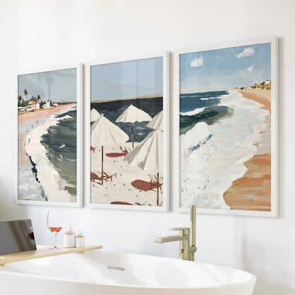 A 3-piece tropical coastline poster set in crisp white frames lines up over the bath, giving the bathroom a fresh, spa-like tone.