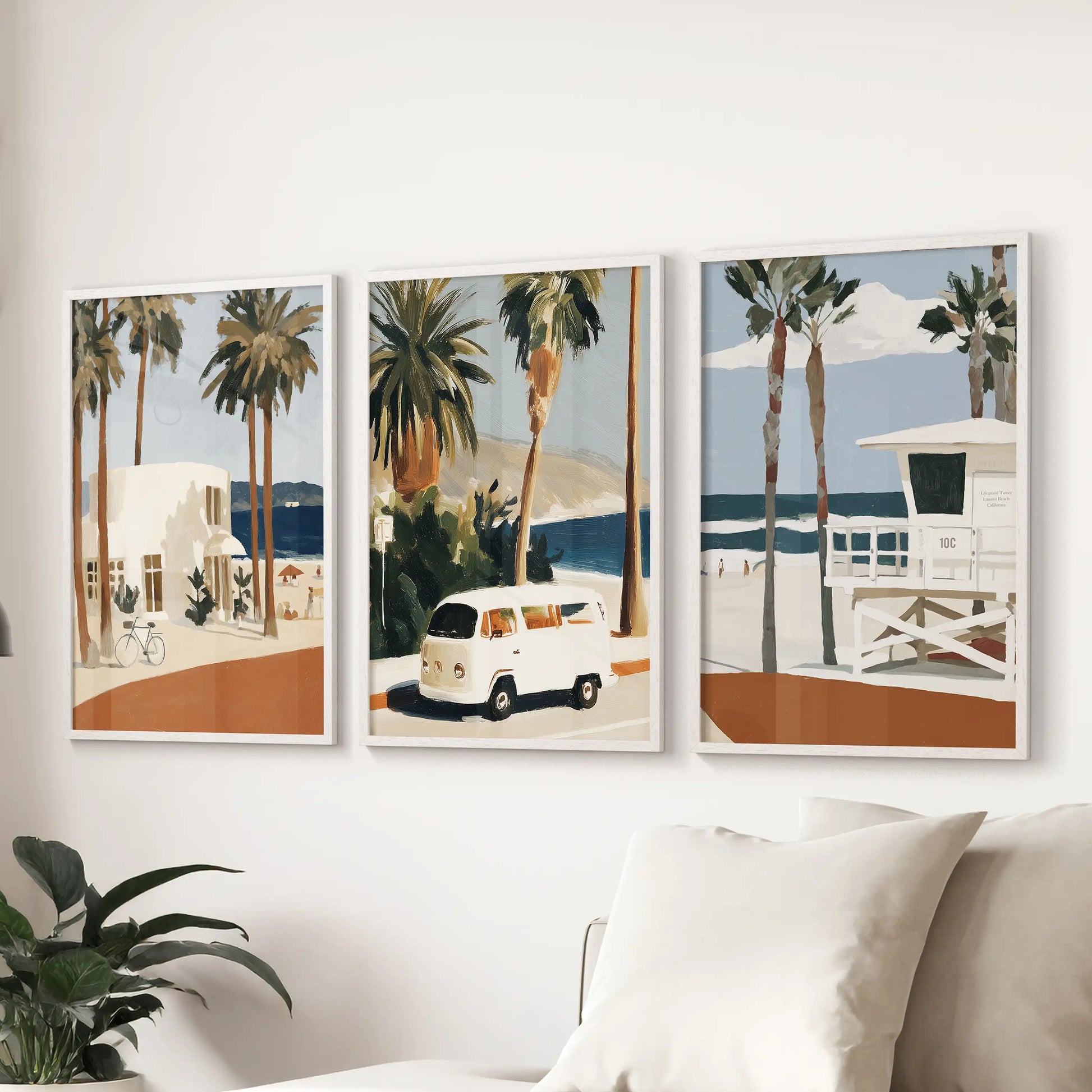 A white-framed 3-print lifeguard tower wall set brightens the living room, stretching cheerfully above a sectional sofa.