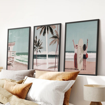 A 3-piece wall art trio shows a surfer girl with her board, each in black frames centered over the headboard for a laid-back coastal bedroom look.